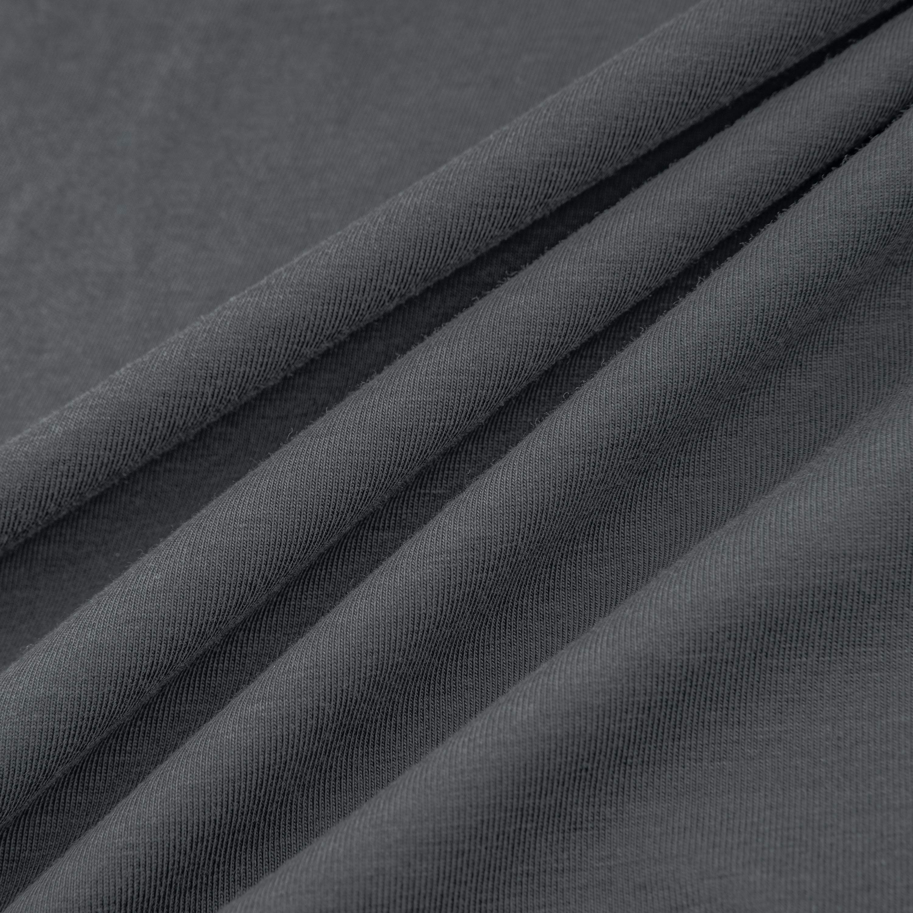 Dark gray cotton fabric, close-up of draped cloth with soft folds and textured surface
